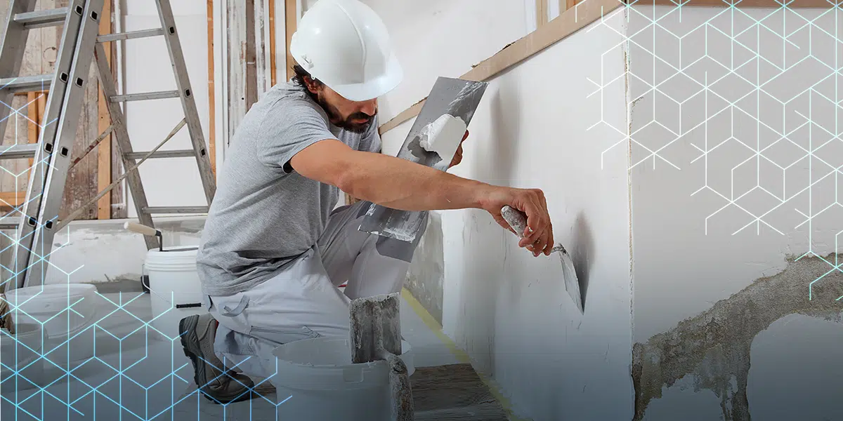 Profissional aplicando reboco/acabamento em parede de obra